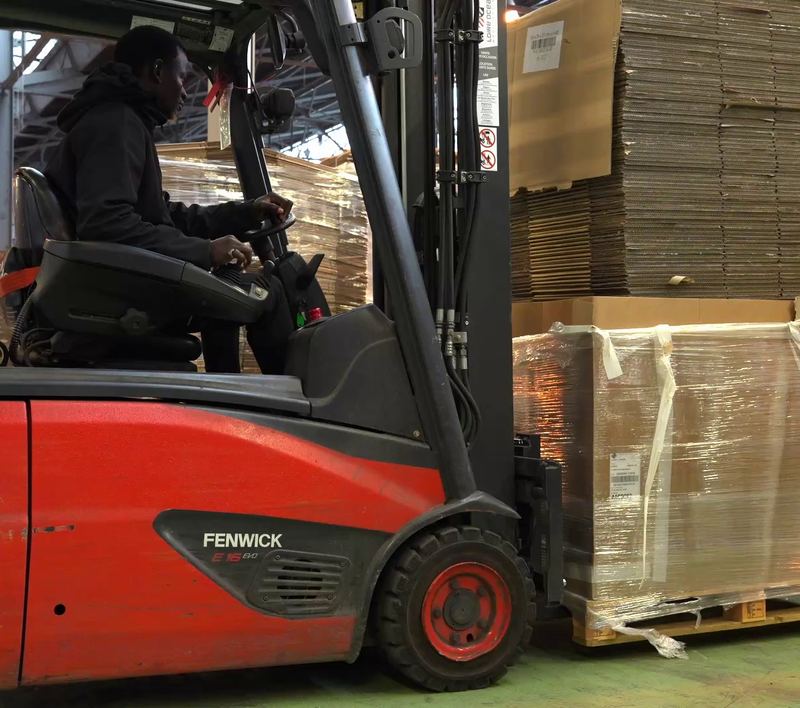 Chargement au chariot élévateur d'une palette de cartons prête à partir