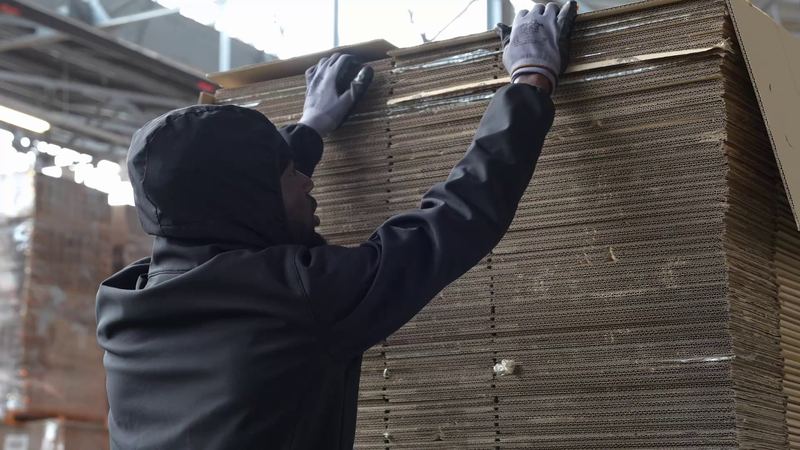 Opérateur Carton Vert empilant des cartons réemployés triés